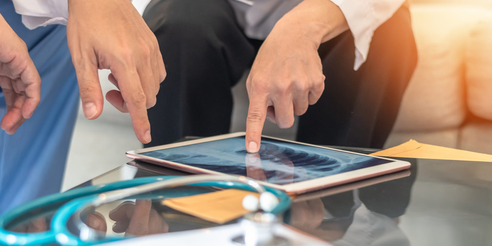 Clinicians hands pointing at a digital x-ray on a display during a discussion