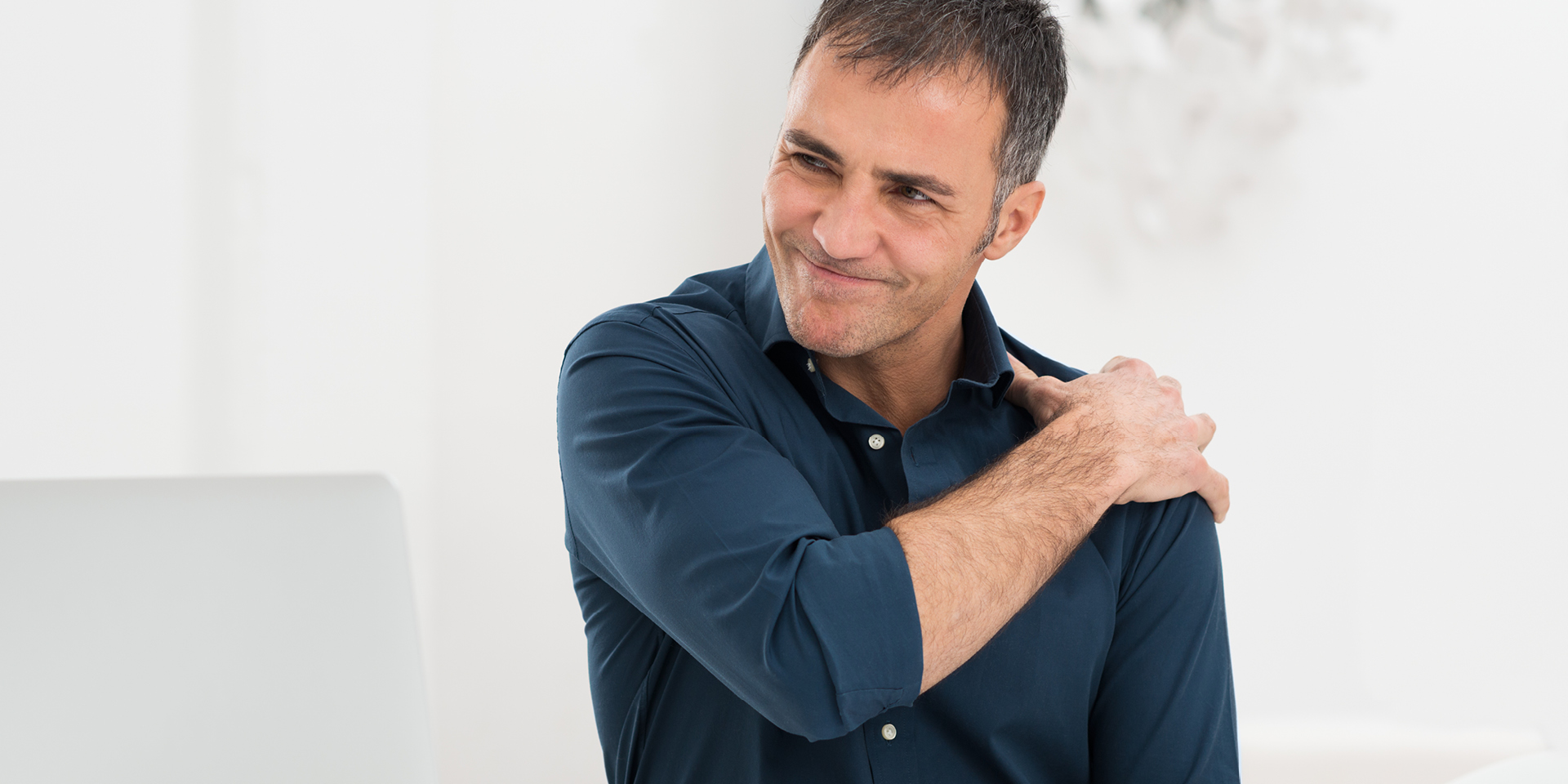 Man holding shoulder in pain