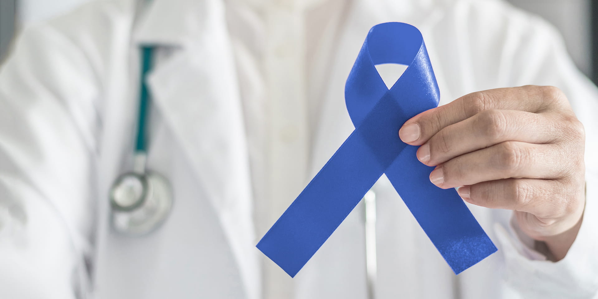 doctor holding blue awareness ribbon