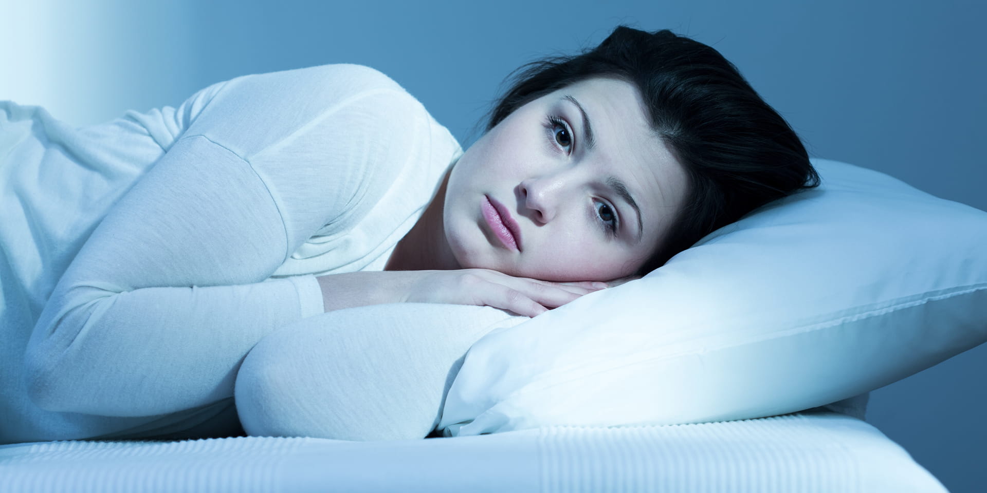 Woman laying on pillow eyes open