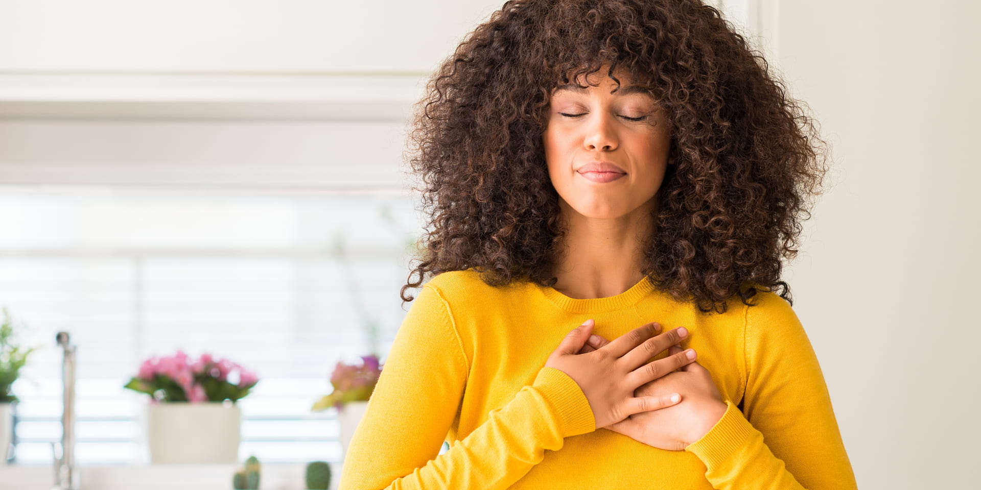 Woman hands on heart eyes closed