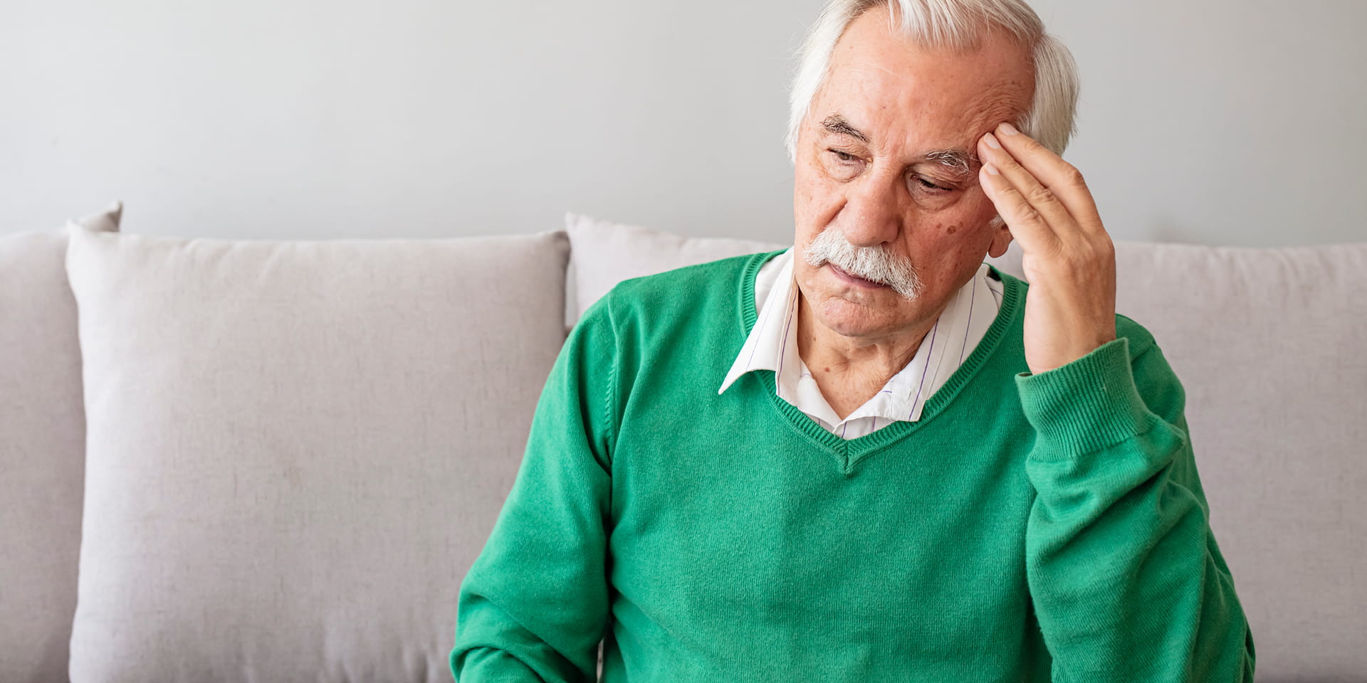 Older man with hand to head