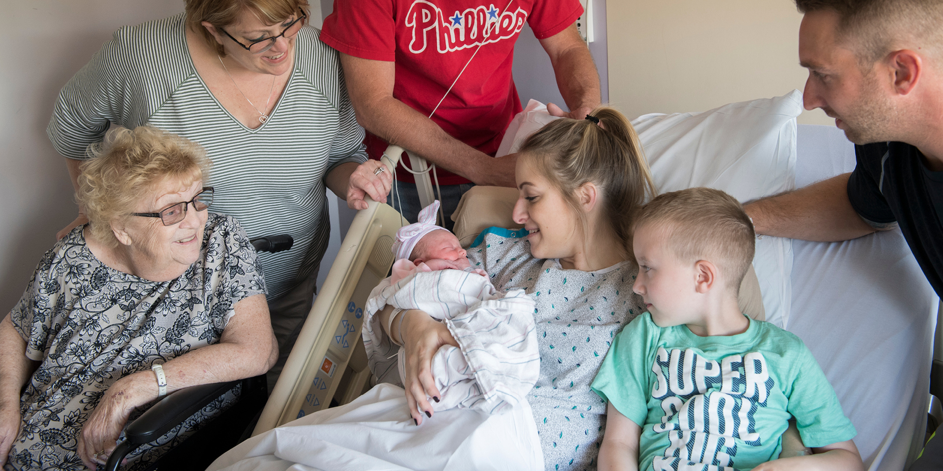 Family surrounding mother with newborn in hospital | Doylestown Health
