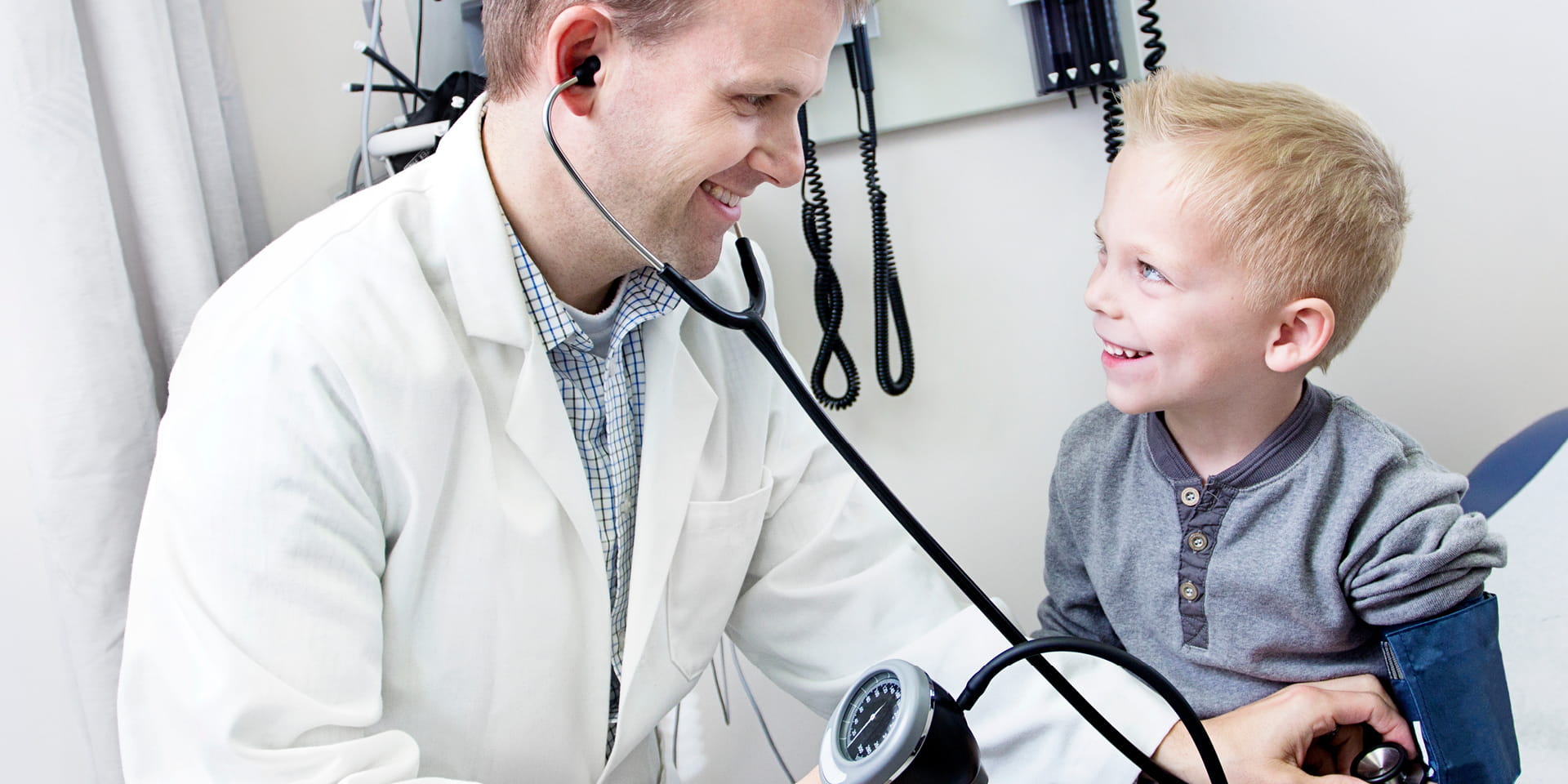 Little boy on exam table with pediatrician
