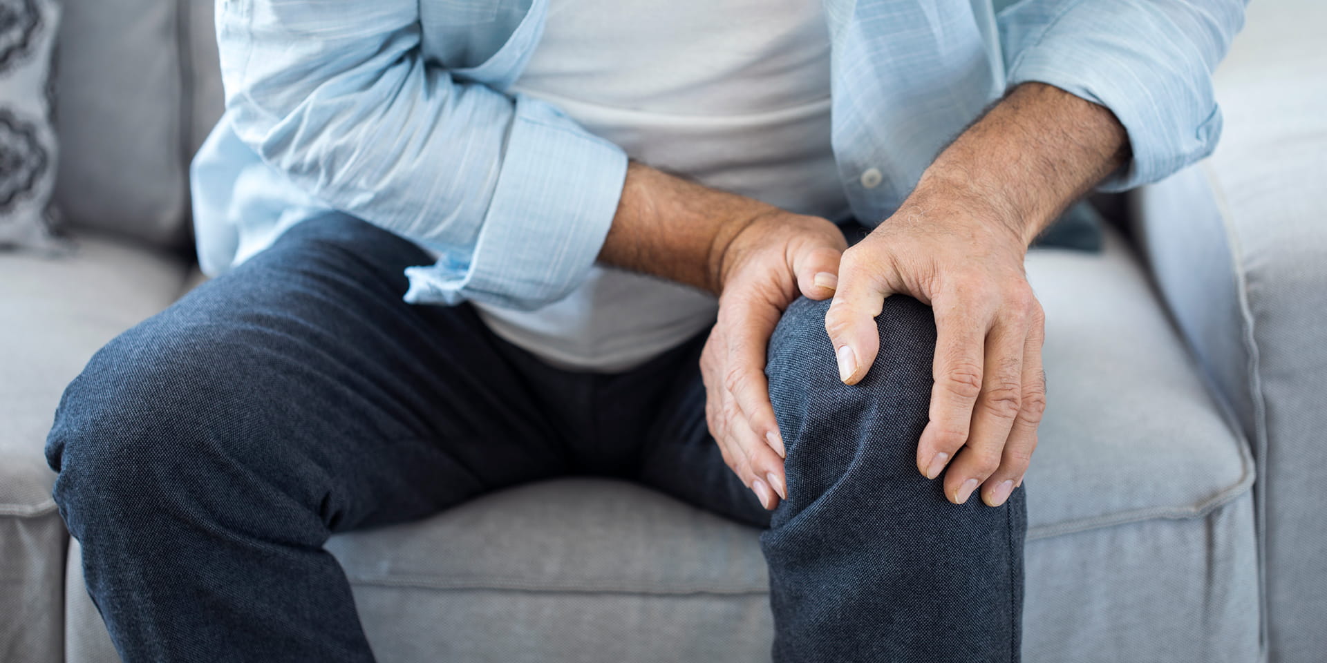 Man gripping knee in pain