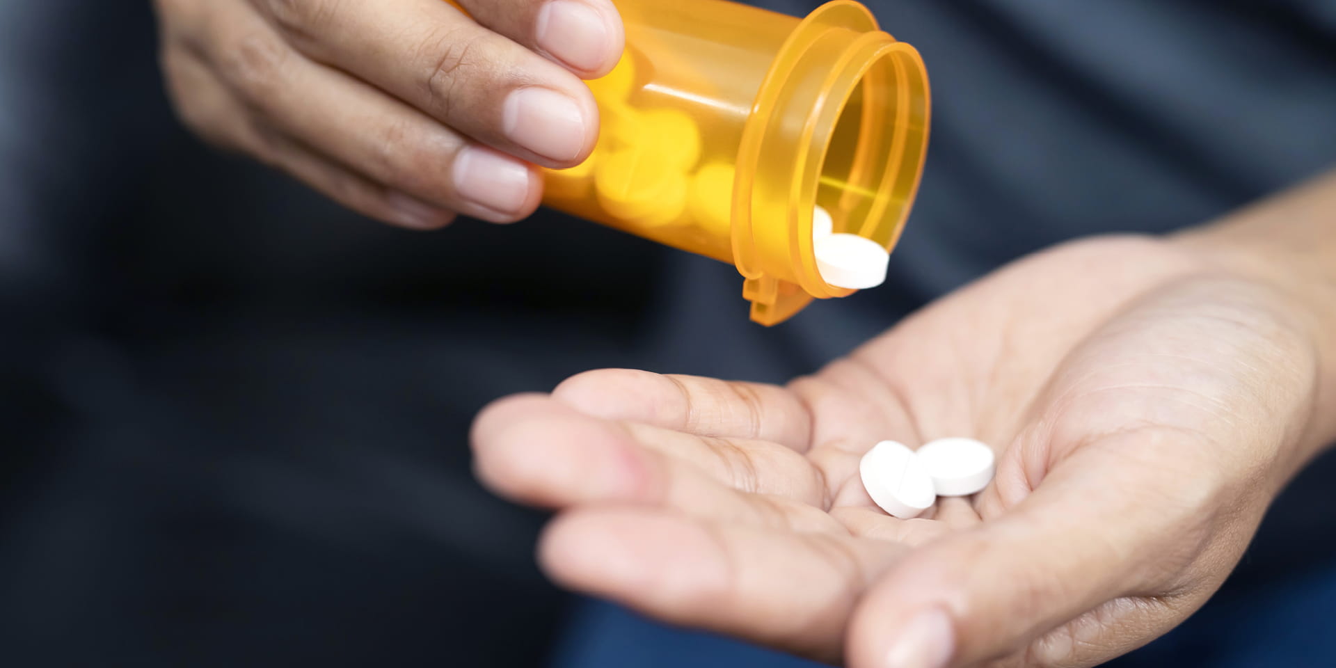 person pouring pills into their hand