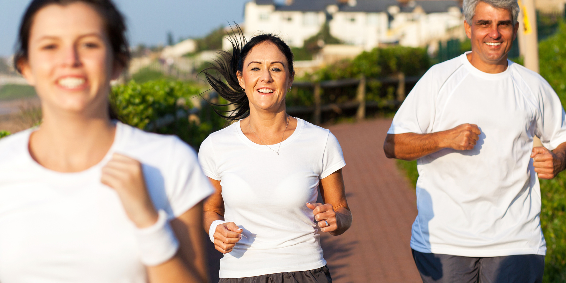 husband, wife, daughter running on the boardwalk