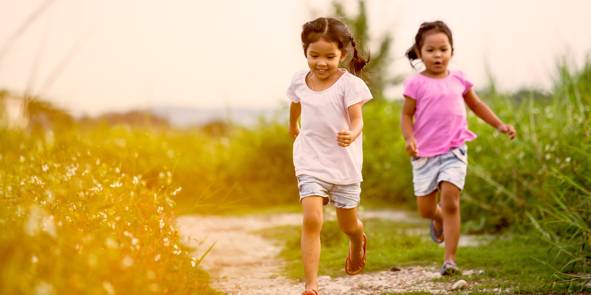 children running on a sandy path