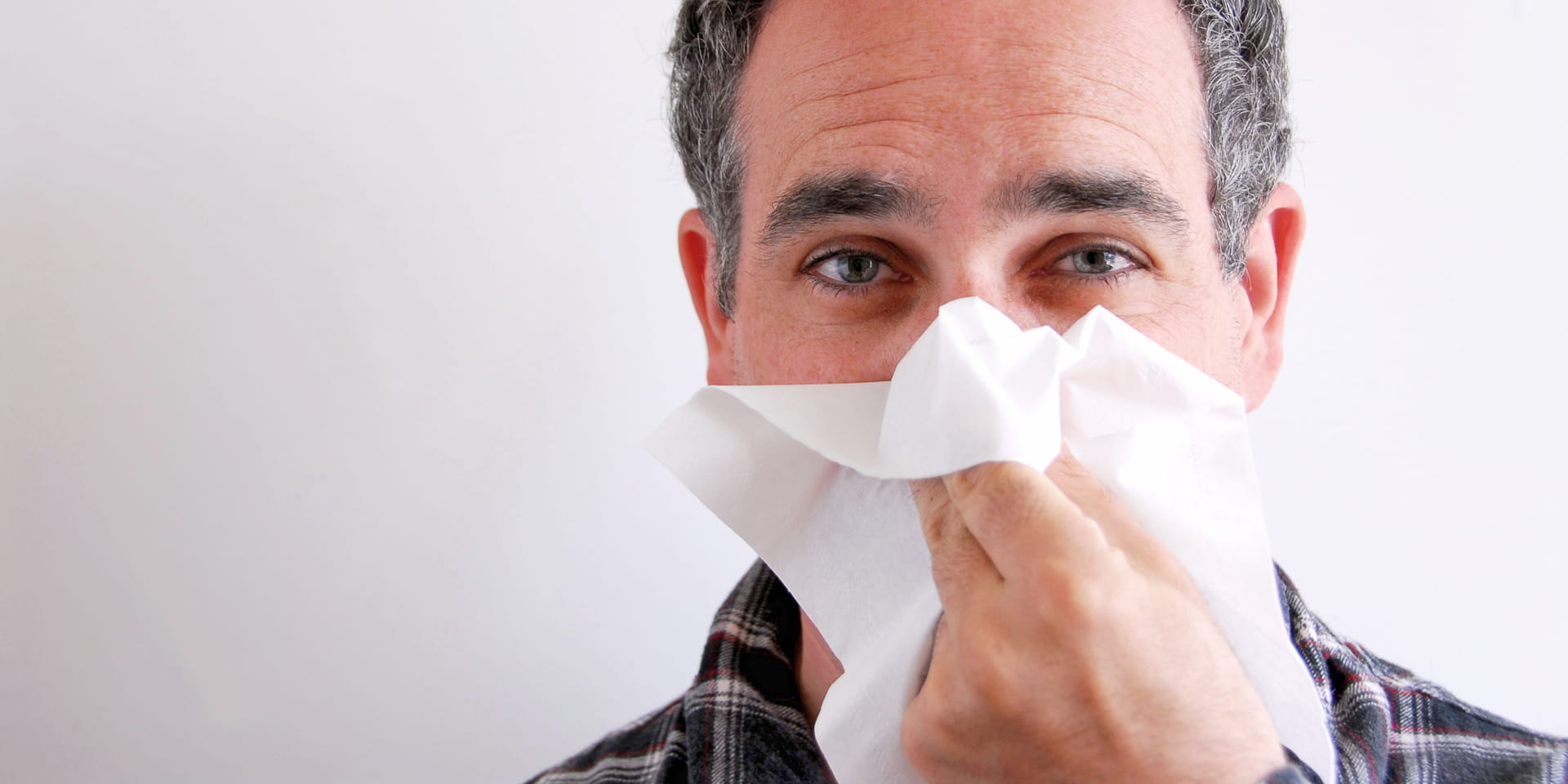 man blowing his nose