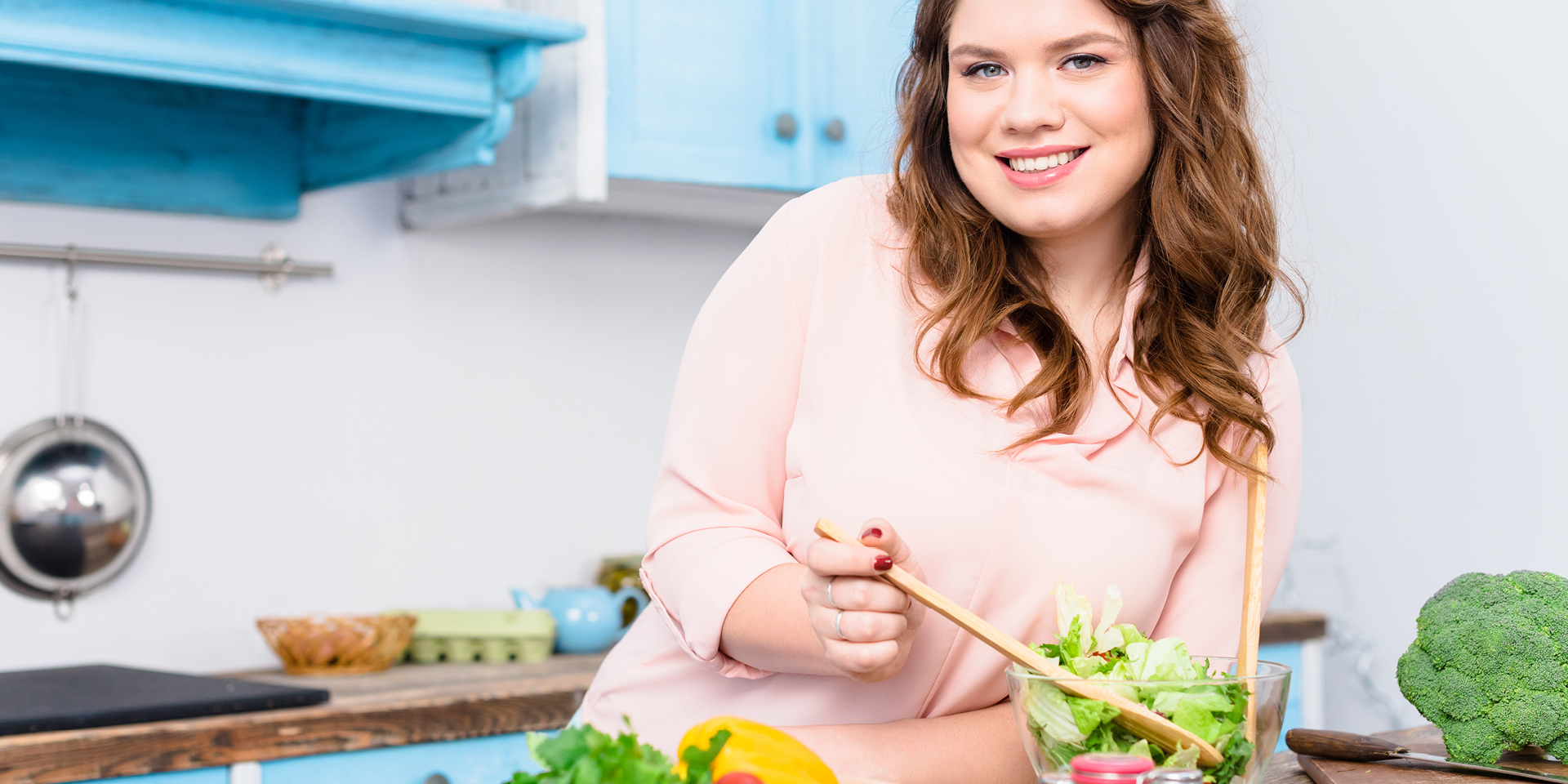 Woman in kitchen prepping salad