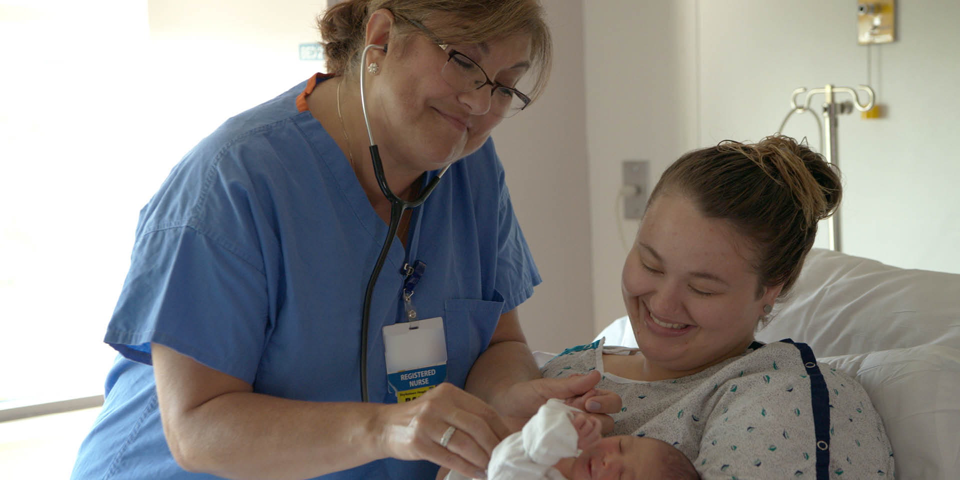 Nurse and mother holding a baby in a Maternity Room | Penn Medicine Doylestown Health