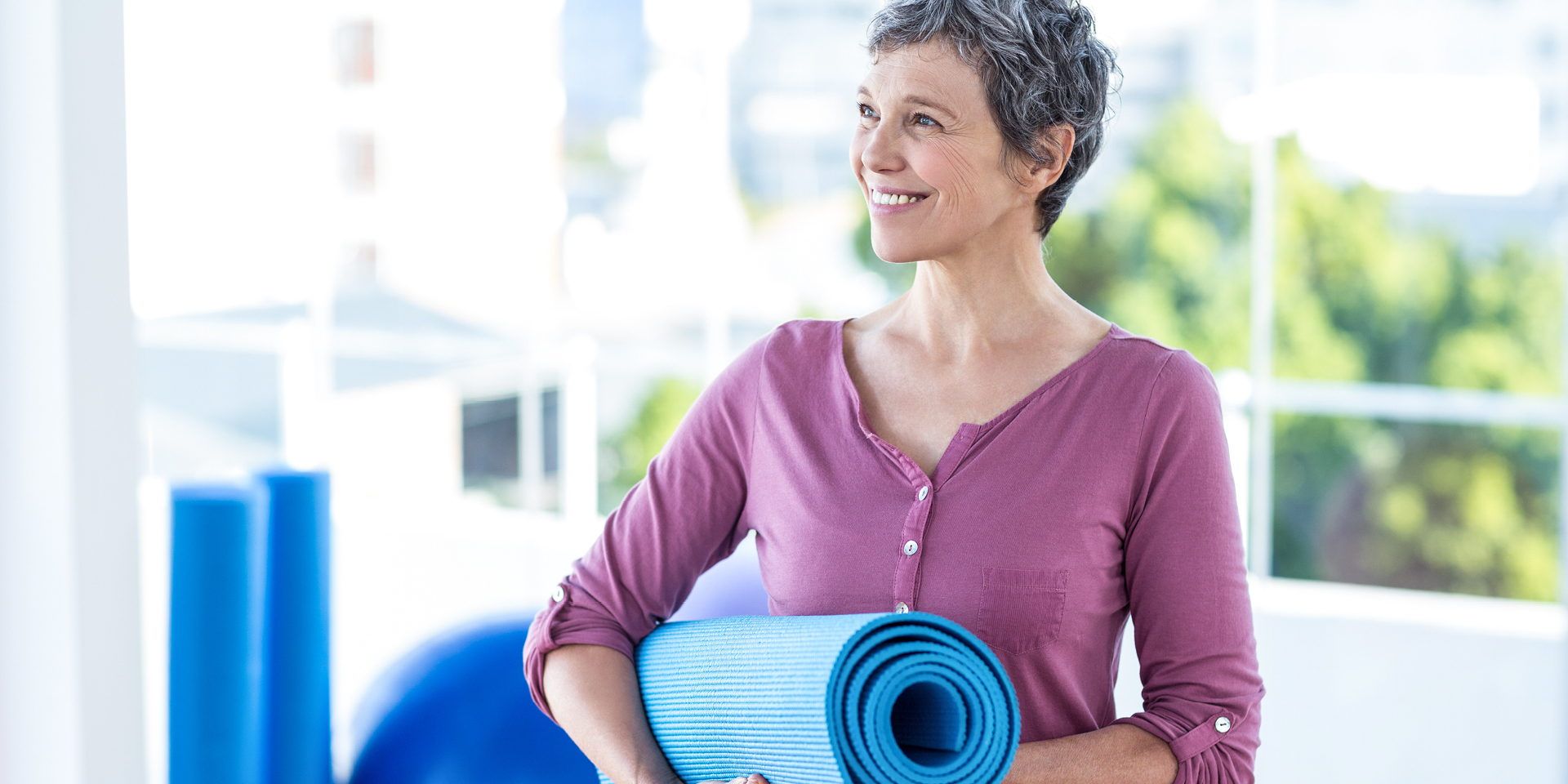 Short-haired woman holding yoga mat
