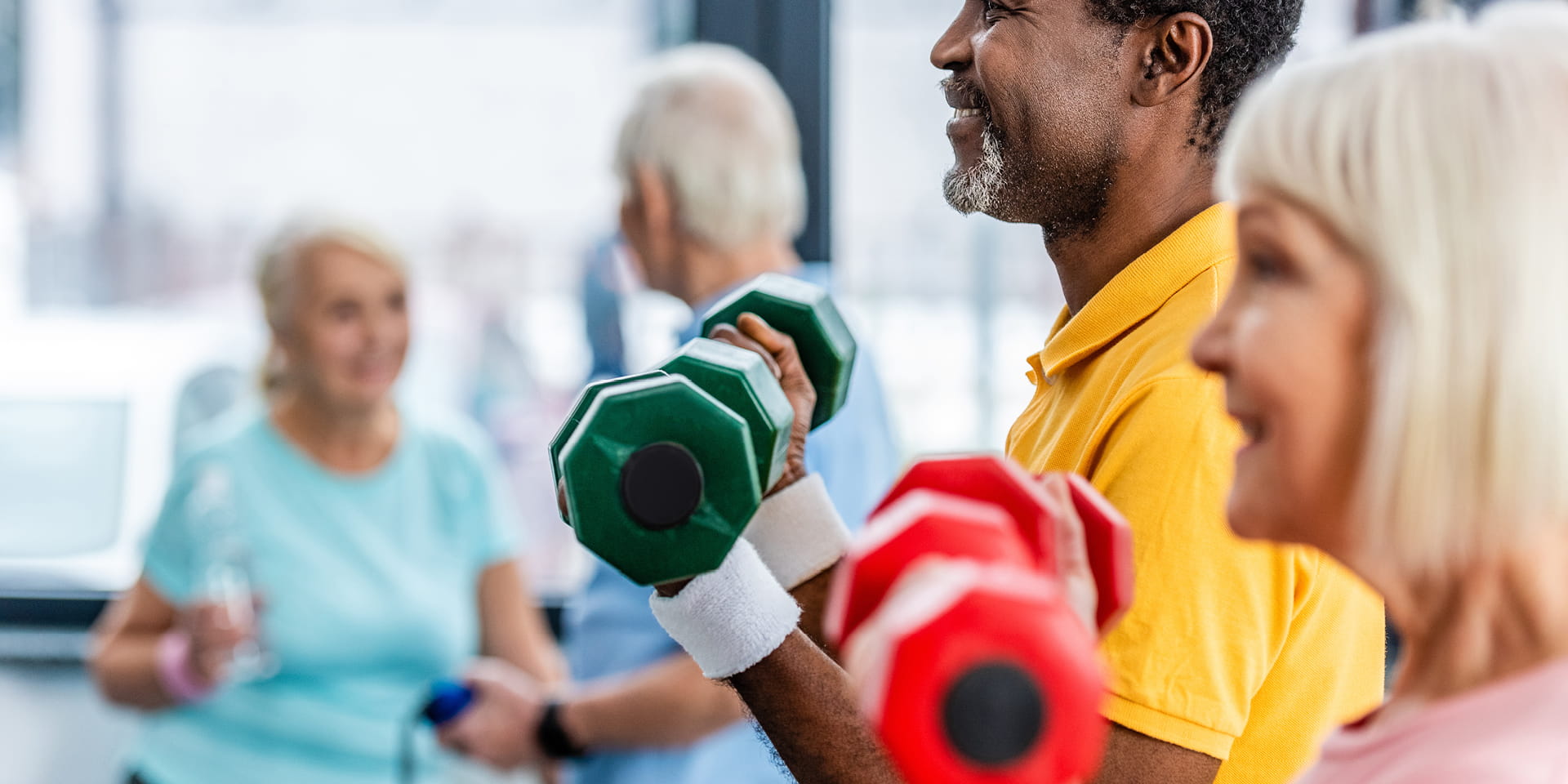 Older couple exercising with dumbbells at gym | Doylestown Health