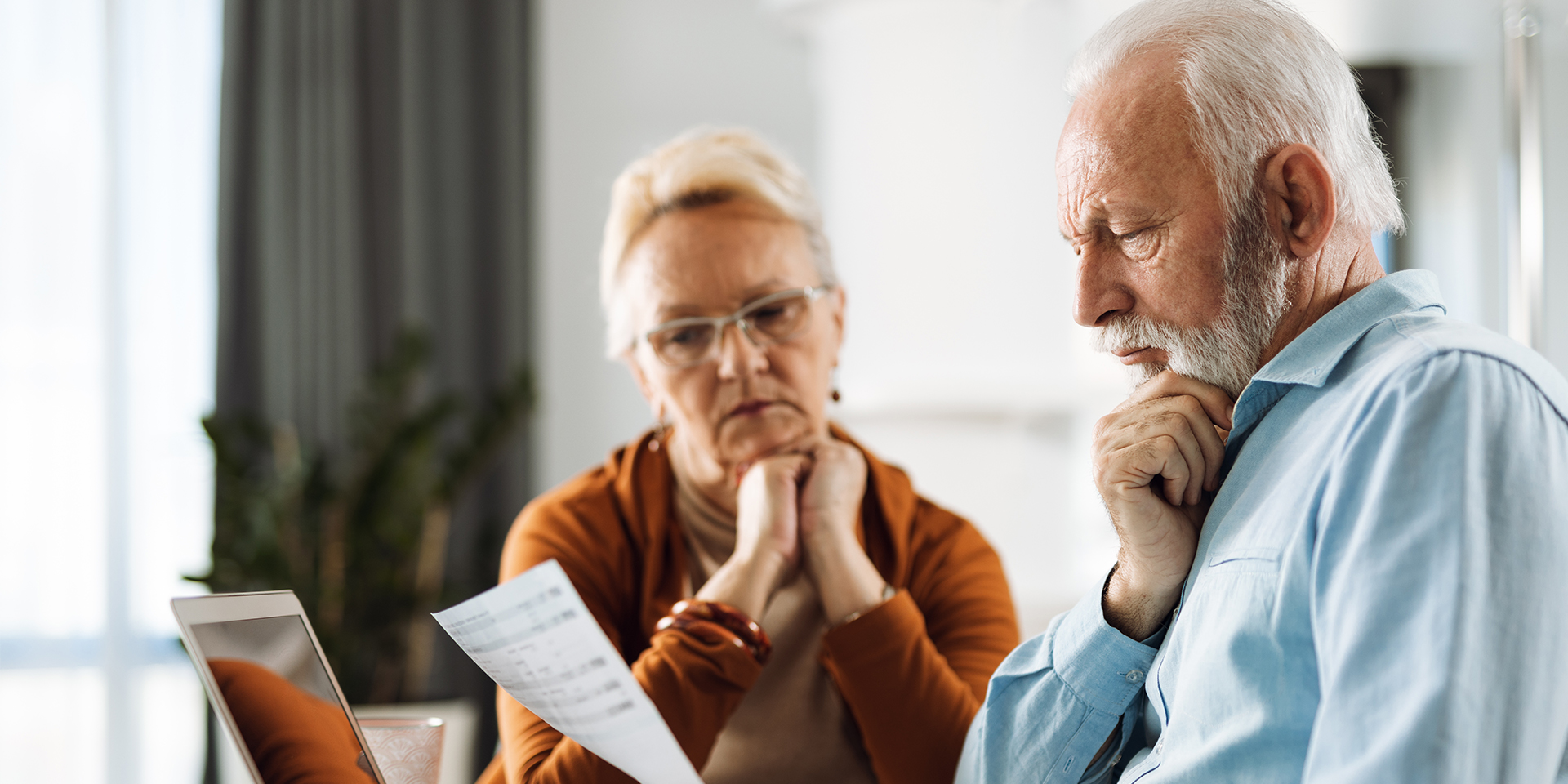 senior man and wife looking at a document