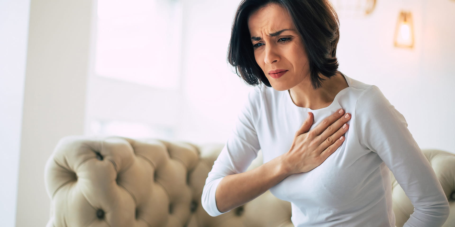 Woman is holding her chest near the heart | Doylestown Health