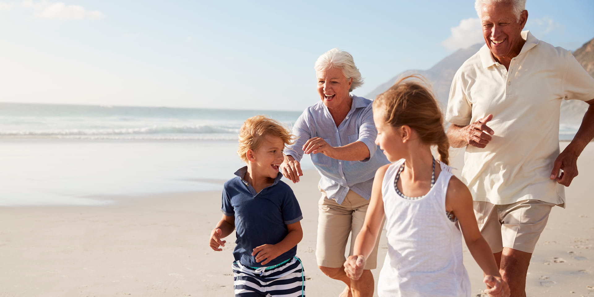 Grand Parents chasing grand kids on the beach by the water | Doylestown Health