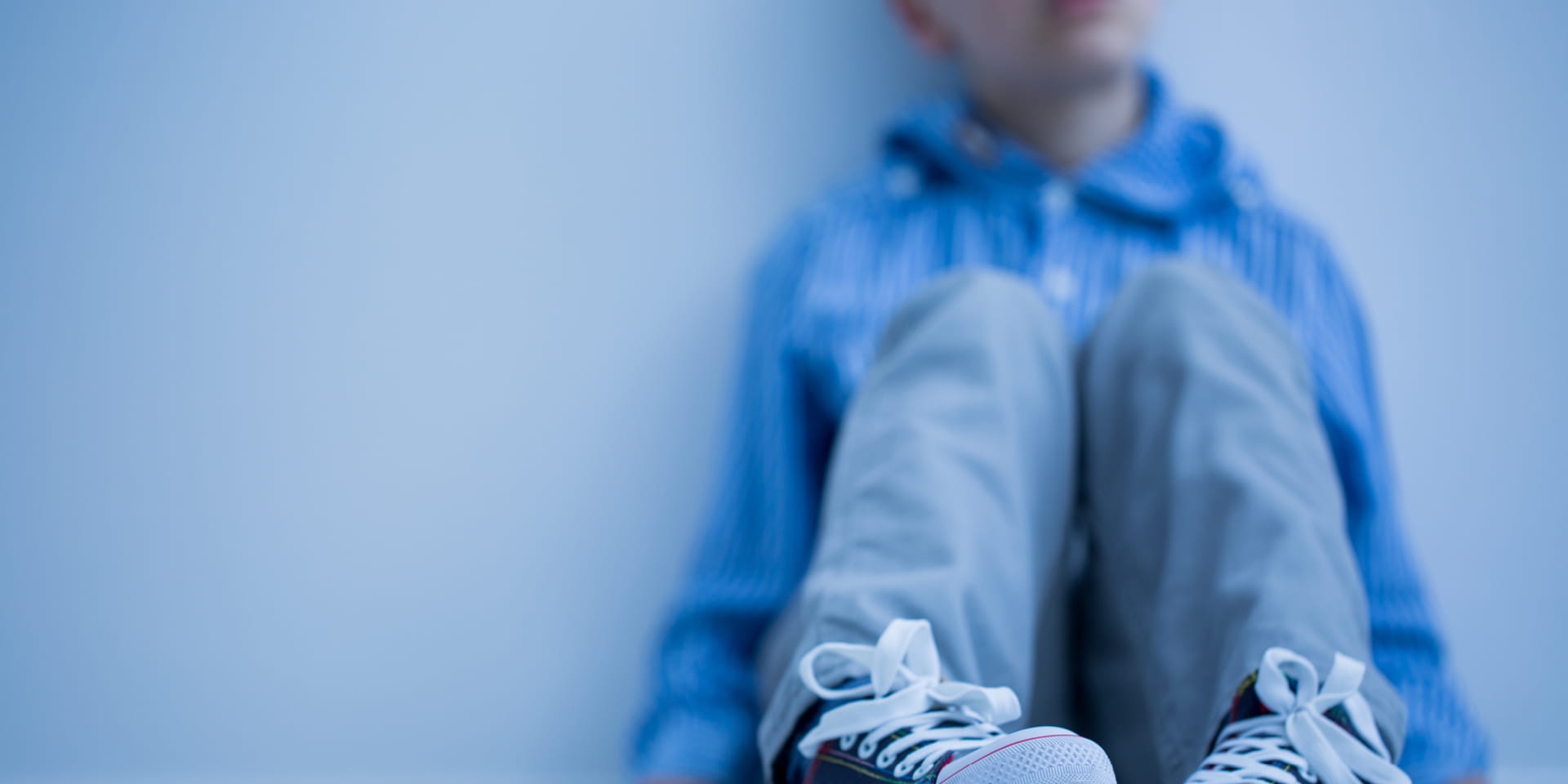 Child is leaning against a wall while seating on the floor | Doylestown Health