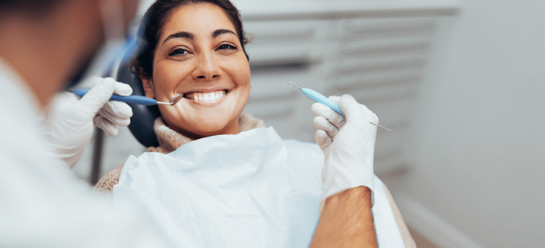 Woman getting dental treatment, patient smiling at a dentist | Doylestown Health